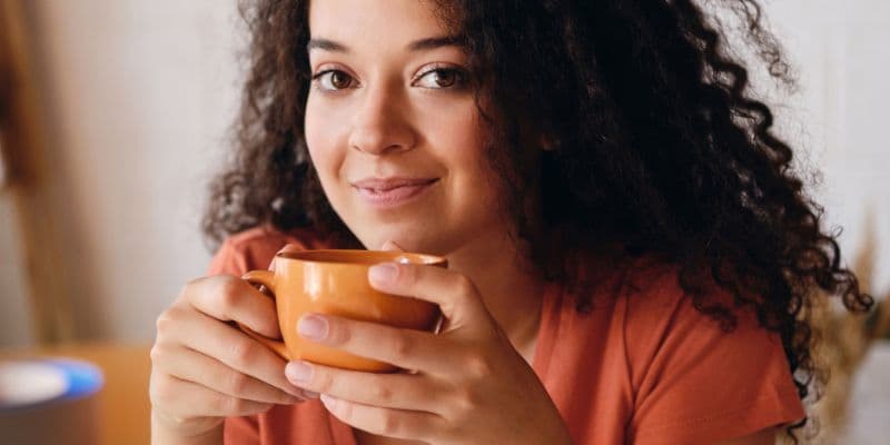Mulher segurando uma xícara de café, tranquila